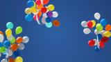 Three bunches of colorful balloons floating upward in a clear blue sky.